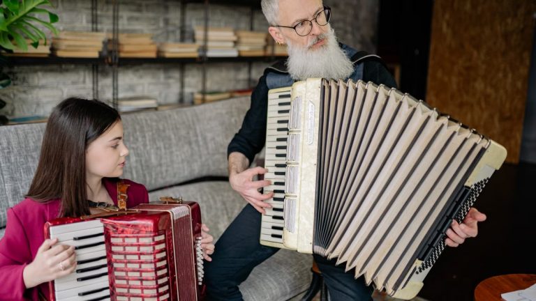 A young girl and her instructor playing accordions during a music lesson indoors.